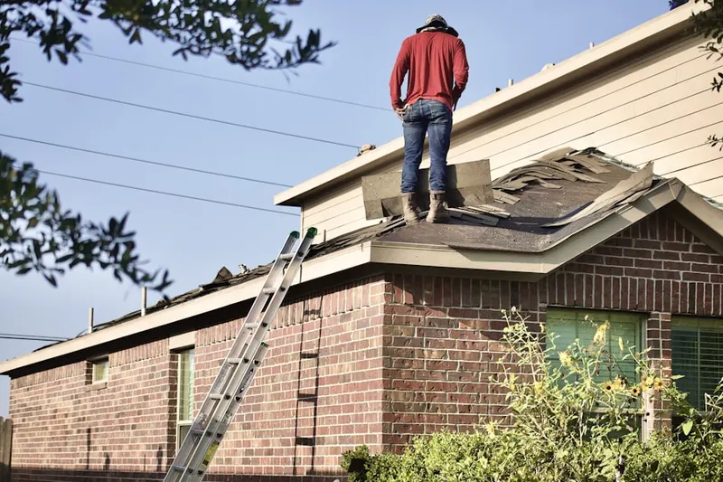 Professional roofer working on a residential roof in Hastings Center